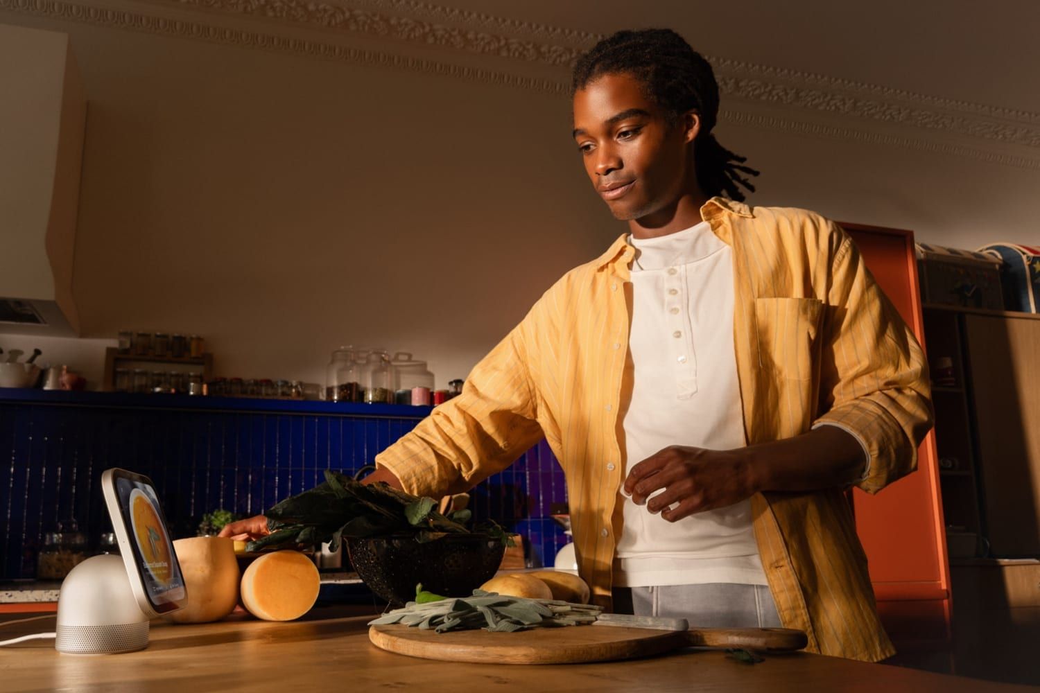 Una persona cocina junto al Apple HomeView, que enseña una receta sobre la encimera