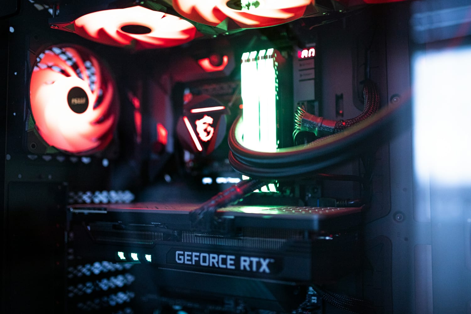 Interior de un PC de juegos con una tarjeta gráfica GeForce RTX y ventiladores iluminados en rojo