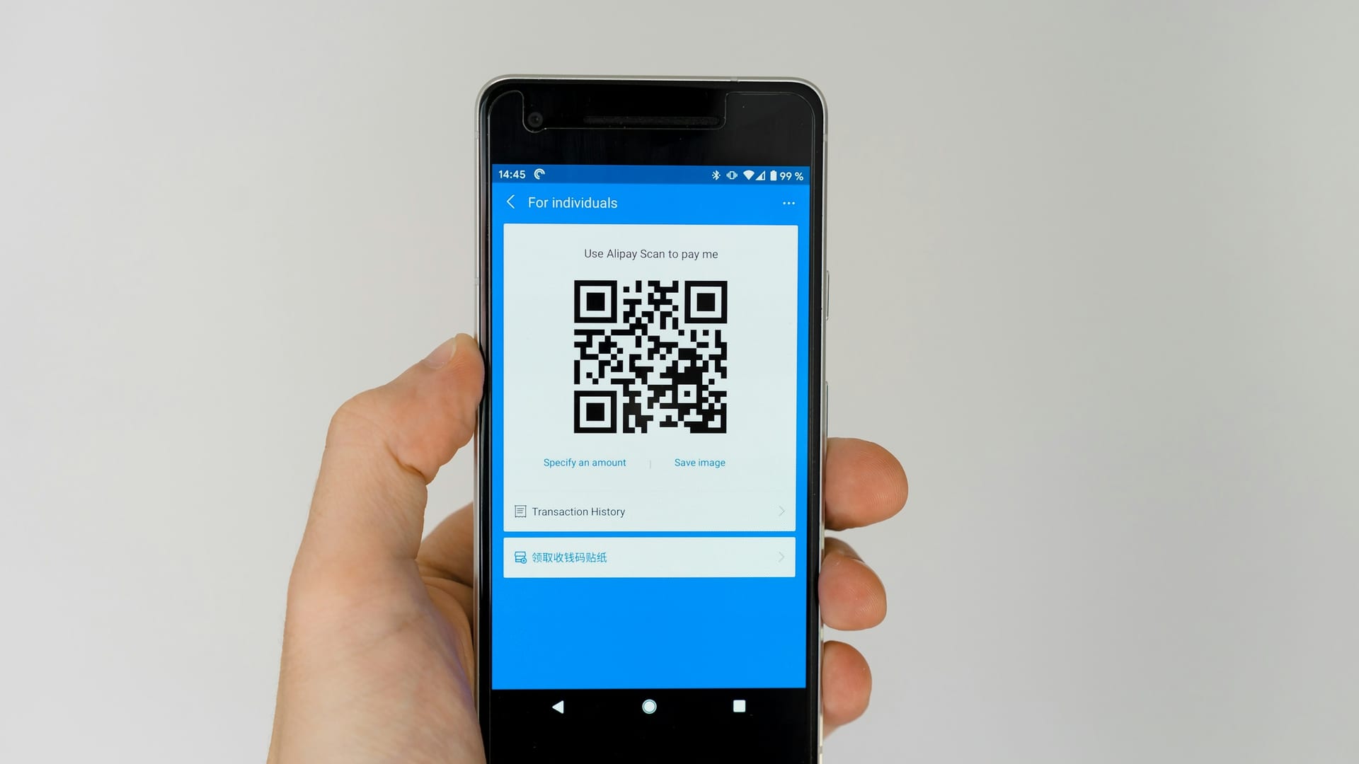 Una mano sujeta un móvil Android que enseña un código QR en la pantalla