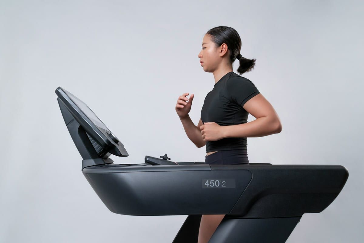 Mujer corriendo en una cinta de correr con barra y consola