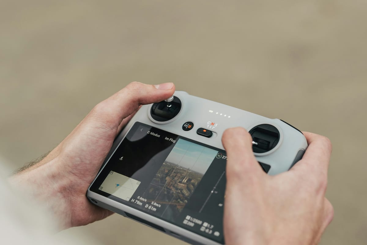 Unas manos sujetan el mando de un dron con pantalla propia