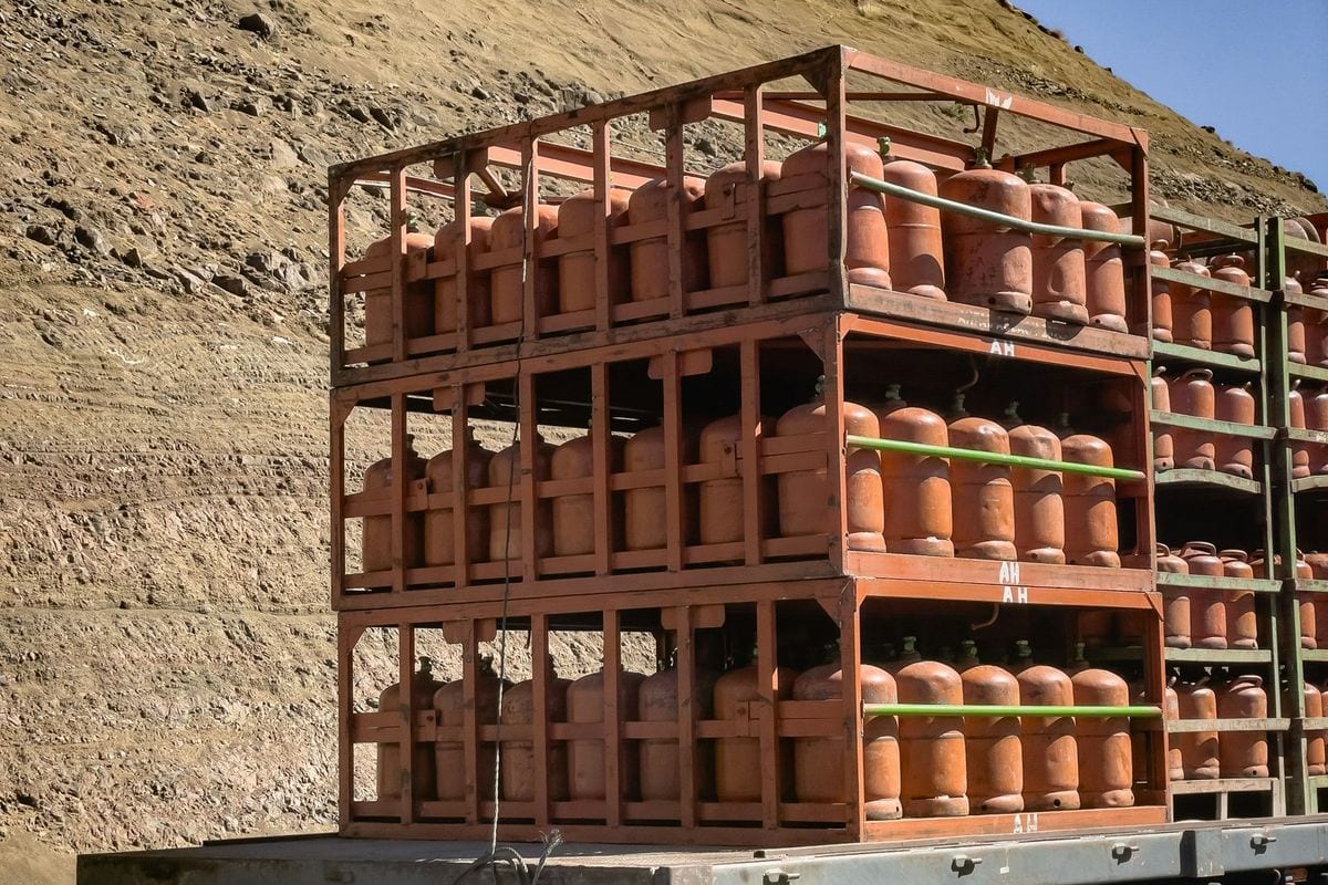 Bombonas de butano naranjas apiladas en jaulas metálicas sobre un camión de reparto