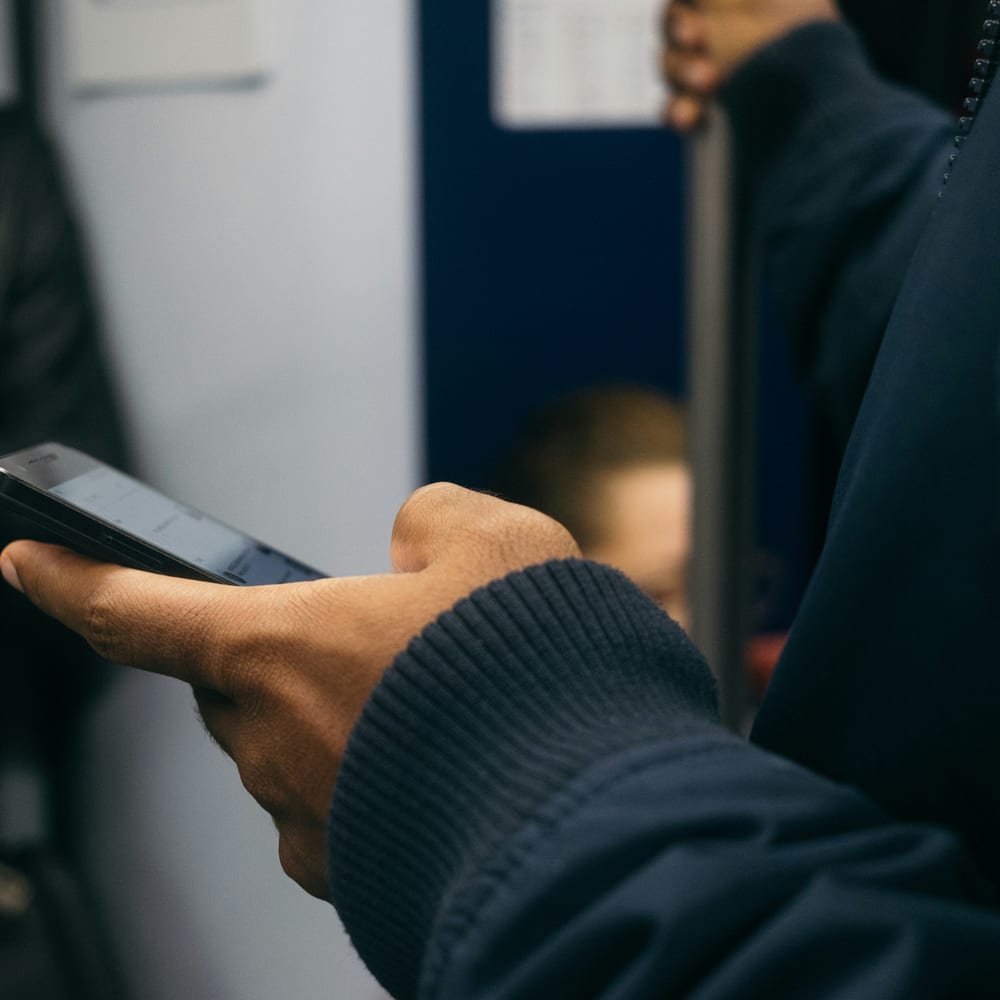 Manos usando un móvil en un vagón de tren