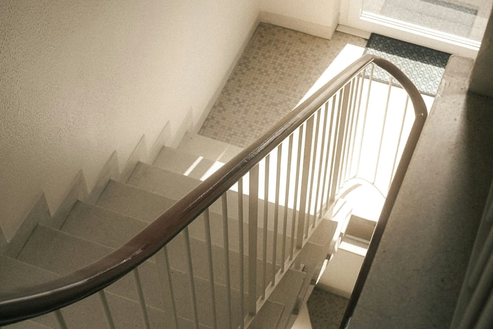 Escalera de ida y vuelta con pasamanos de madera, vista desde arriba