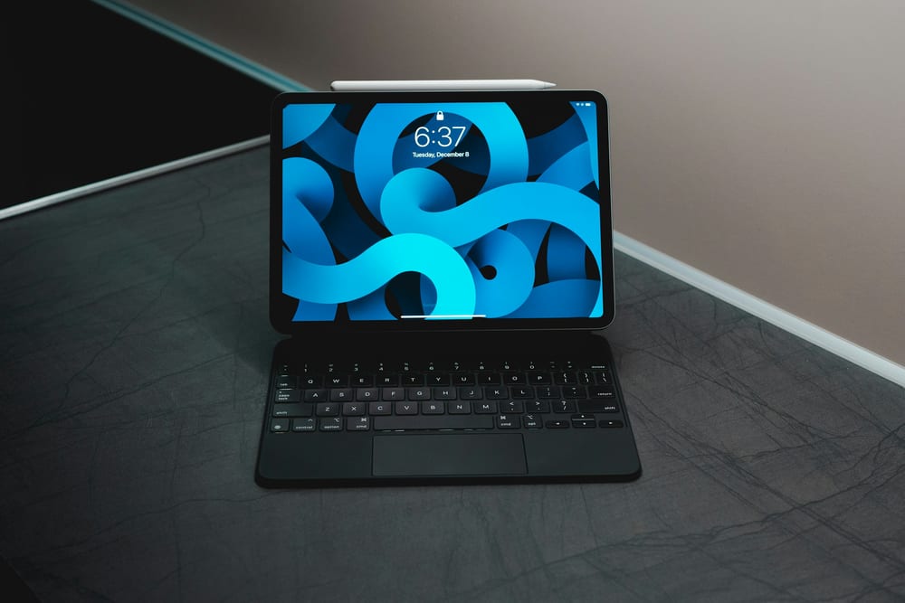 Un iPad Air sobre su Magic Keyboard en una mesa oscura