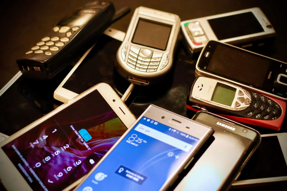 Un montón de móviles antiguos de varias épocas, de teclas y de pantalla táctil